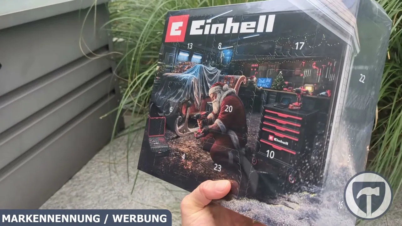 Die Vorderseite des Einhell Werkzeug-Adventskalenders zeigt ein weihnachtliches Werkstattmotiv mit den nummerierten Türchen.